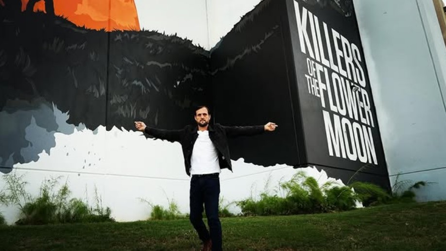 Samuel French beside Killers of the Flower Moon artwork